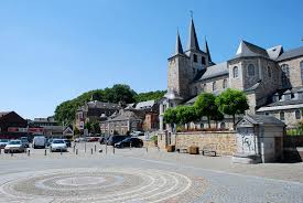 Vue sur le centre-ville d'Amay avec une station-service locale, essentielle pour la vidange Amay, et ses rues bordées d'arbres.
