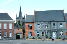 Camion de vidange sur paysage urbain de Chièvres avec bâtiments typiques et rues pavées. Vidange Chièvres en action.