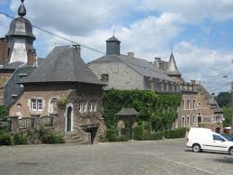 Centre de Dalhem avec maisons en pierre et camion de service Vidange Dalhem stationné près d'une ruelle pittoresque