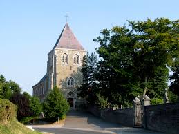 Scène de vidange à Fexhe-le-Haut-Clocher avec ancienne église en arrière-plan et rues pavées typiques du village belge.