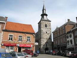 Équipe de débouchage Florennes en action devant l'église Sainte-Gangulf, rue animée et typique de la ville.