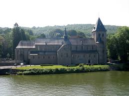 Vue pittoresque sur Hastière avec bâtiments en briques rouges et camion de débouchage stationné, Débouchage Hastière.