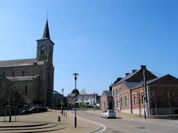 Camion de vidange à Havelange devant l'église Saint-Martin, typique avec son clocher et son architecture en pierre locale