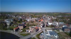 Rue pittoresque de Merbes-le-Château avec artisan local spécialisé en débouchage, scène typique du village charmant.