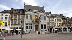 Scène urbaine à Ath avec rues pavées, bâtiments historiques, illustrant le service de débouchage dans la région d'Ath.