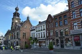 Vue urbaine de Binche avec rue pavée et bâtiments anciens, idéal pour services de débouchage Binche rapides et efficaces.