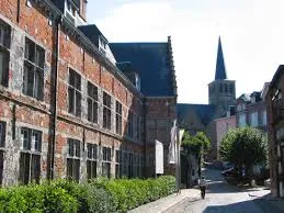 Rue pavée à Lessines avec maisons anciennes, signalisation de débouchage, ambiance typique et charmante du centre-ville