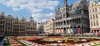 Rue animée de Mouscron avec camion de vidange en action Vidange Mouscron, familles se promenant sous un ciel bleu.