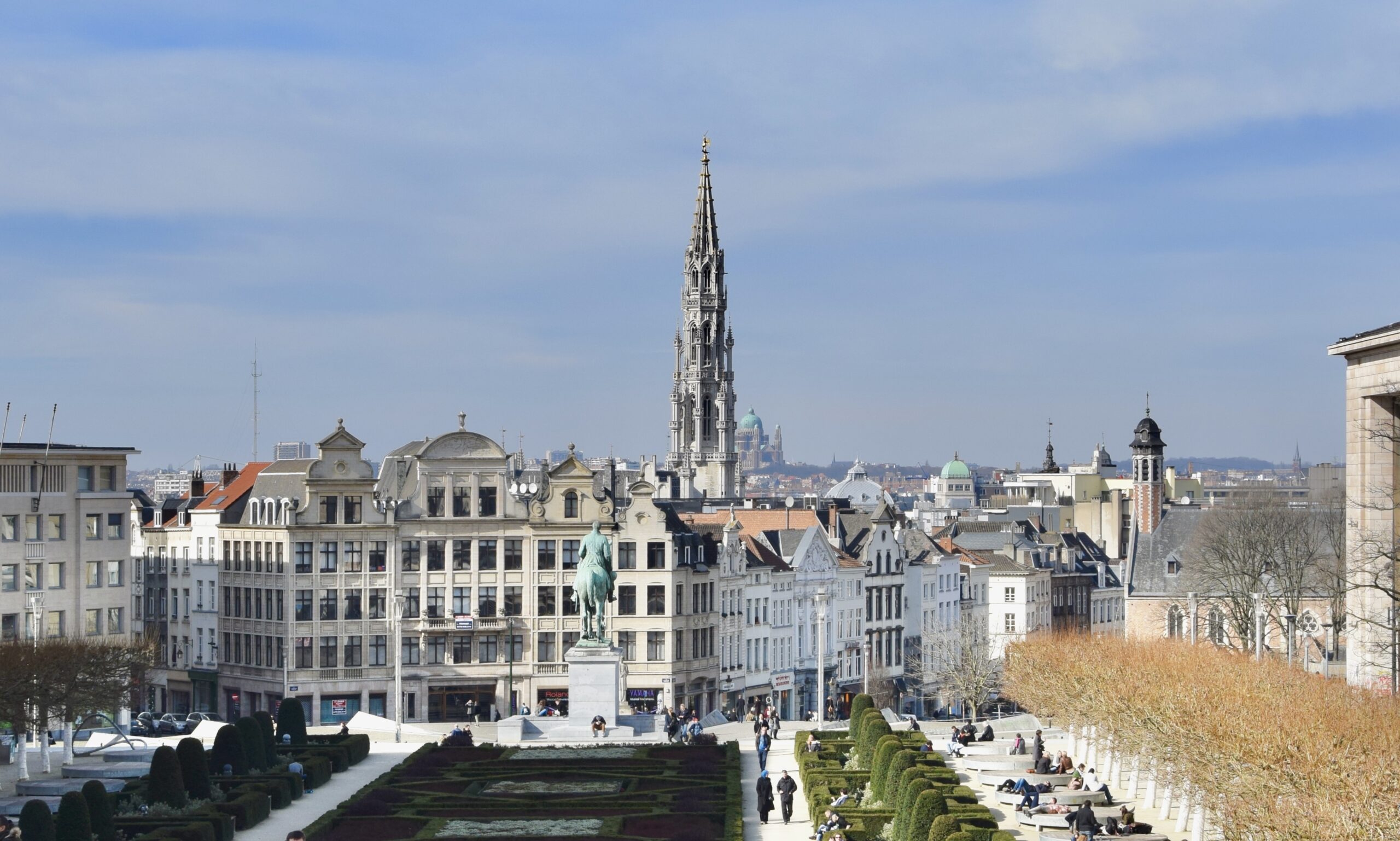Scène de débouchage à Bruxelles avec un plombier devant la Grand-Place, architecture gothique et rue pavée animée.